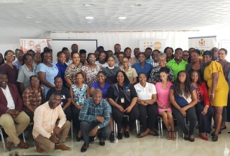 Acting Director for the Community Liaison Unit of the Bureau of Gender Affairs (BGA), Nardia McLaren (seated, fifth left) and United Nations Population Fund (UNFPA) Emergency Response Specialist, Gender-Based Violence (GBV) in Emergency, Mary Oyella (seated, sixth left), share a moment with participants in a recent four-day workshop on Gender-Based Violence (GBV) in Emergency Preparedness and Response, at Tropics View Hotel in Hatfield, Mandeville. The workshop was organised by the BGA in partnership with the UNFPA Sub-Regional Office for the Caribbean. More than 50 stakeholders drawn from various community-based organisations, non-governmental organisations and ministries, departments and agencies (MDAs) registered for the training, which is part of the Government's National Strategic Action Plan to eliminate violence in Jamaica.

