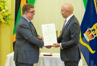 Governor- General, His Excellency the Most Hon. Sir Patrick Allen (right), presents newly installed Custos Rotulorum of St. Ann, Joseph Issa, with the Instrument of Office during a swearing-in ceremony on Monday (September 16) at King's House.

