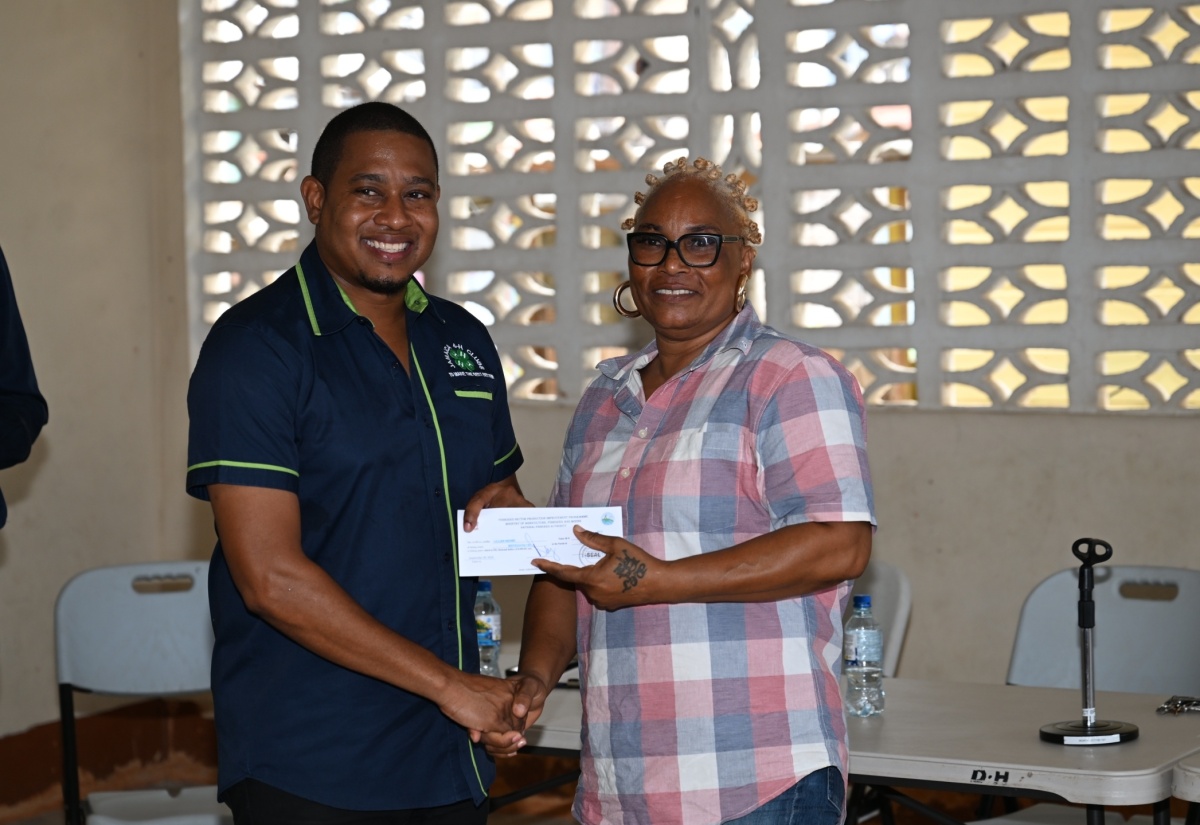 Minister of Agriculture, Fisheries and Mining, Hon. Floyd Green, presents a cash voucher to fisher, Lillian Brown, during the National Fisheries Authority’s (NFA) post- Hurricane Beryl relief programme in Whitehouse, Westmoreland, on Friday (August 30). Fisherfolk sustaining losses during the hurricane’s passage on July 3, received cash vouchers.

