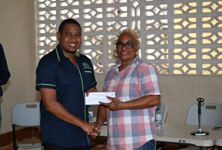 Minister of Agriculture, Fisheries and Mining, Hon. Floyd Green, presents a cash voucher to fisher, Lillian Brown, during the National Fisheries Authority’s (NFA) post- Hurricane Beryl relief programme in Whitehouse, Westmoreland, on Friday (August 30). Fisherfolk sustaining losses during the hurricane’s passage on July 3, received cash vouchers.

