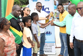 Mayor of Montego Bay and Chairman of the St. James Municipal Corporation, Councillor Richard Vernon (third right), cuts the ribbon to officially open the bridge linking Cornwall Courts and Green Pond communities in St. James, on Sunday, September 1.  Assisting are St James Central Member of Parliament and Deputy Speaker of the House, Heroy Clarke (sixth left); Government Senator, Charles Sinclair (right); Councillor of the Salt Spring Division, Gregory Harris (second right); and Councillor for the Montego Bay South Eastern Division, Arthur Lynch (second left); and community members.

