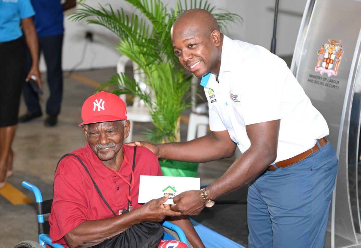 Minister of Labour and Social Security, Hon. Pearnel Charles Jr. (right), hands over a cheque to St. Ann beneficiary, Richard Walker, who was impacted by Hurricane Beryl, during the Rebuild Jamaica cheque presentation, held at the Ministry of Labour and Social Security office in St. Ann’s Bay, St. Ann, on Thursday, September 5.

