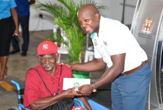 Minister of Labour and Social Security, Hon. Pearnel Charles Jr. (right), hands over a cheque to St. Ann beneficiary, Richard Walker, who was impacted by Hurricane Beryl, during the Rebuild Jamaica cheque presentation, held at the Ministry of Labour and Social Security office in St. Ann’s Bay, St. Ann, on Thursday, September 5.

