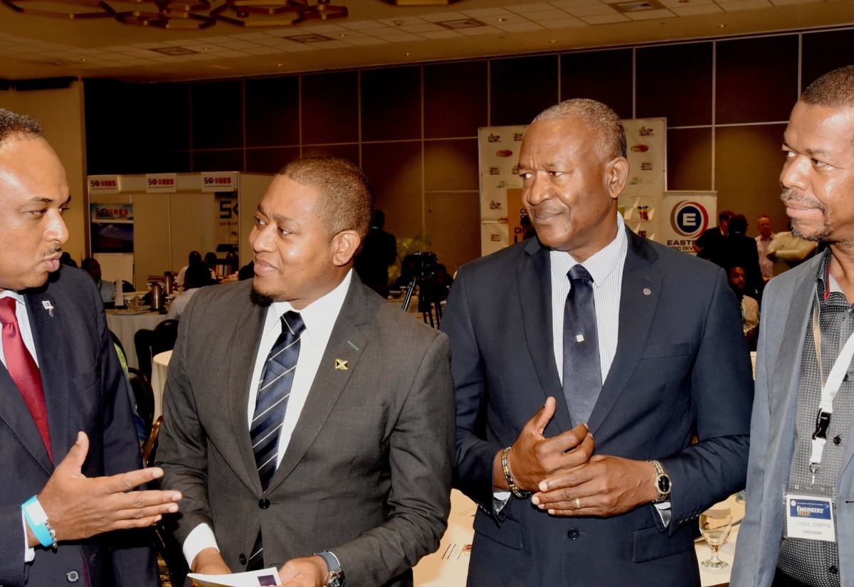 Agriculture, Fisheries and Mining Minister, Hon. Floyd Green (second left), listens to a point from Managing Director, Jamaica Social Investment Fund (JSIF) Omar Sweeney, during a tour of booths at the Jamaica Institution of Engineers’ (JIE’s) Engineers Week Conference on Tuesday (September 17) at The Jamaica Pegasus hotel in New Kingston. Sharing in the conversation are Chairman of Professional Engineers Registration Board (PERB), Glaister Ricketts (second right); and President of the JIE,  Oneil Josephs.

