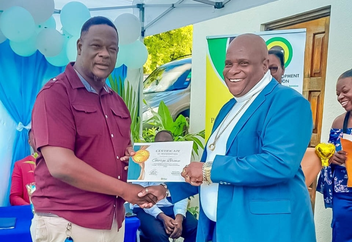 Parish Manager for the Social Development Commission (SDC) in Portland, Karl Coke (left), presents a Certificate of Recognition to Treasurer of the Buff Bay Development Area Committee (DAC), George Brown, at the staging of the inaugural Portland DAC Retreat held recently at Barhanna Vista Lodge in Port Antonio. The event, organised by the SDC through its Participatory Governance Programme, focused on community leadership and development.