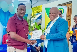 Parish Manager for the Social Development Commission (SDC) in Portland, Karl Coke (left), presents a Certificate of Recognition to Treasurer of the Buff Bay Development Area Committee (DAC), George Brown, at the staging of the inaugural Portland DAC Retreat held recently at Barhanna Vista Lodge in Port Antonio. The event, organised by the SDC through its Participatory Governance Programme, focused on community leadership and development.