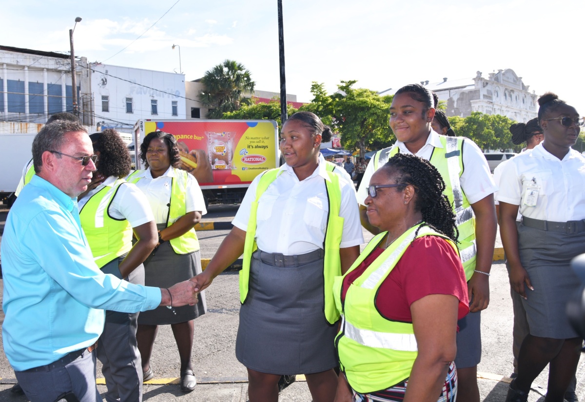 Minister of Science, Energy, Telecommunications and Transport, Hon. Daryl Vaz (left), greets Transport Authority(TA) team members in downtown Kingston on Wednesday (September 4), while observing the rollout of new buses recently acquired by the Jamaica Urban Transit Company (JUTC).

