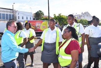 Minister of Science, Energy, Telecommunications and Transport, Hon. Daryl Vaz (left), greets Transport Authority(TA) team members in downtown Kingston on Wednesday (September 4), while observing the rollout of new buses recently acquired by the Jamaica Urban Transit Company (JUTC).

