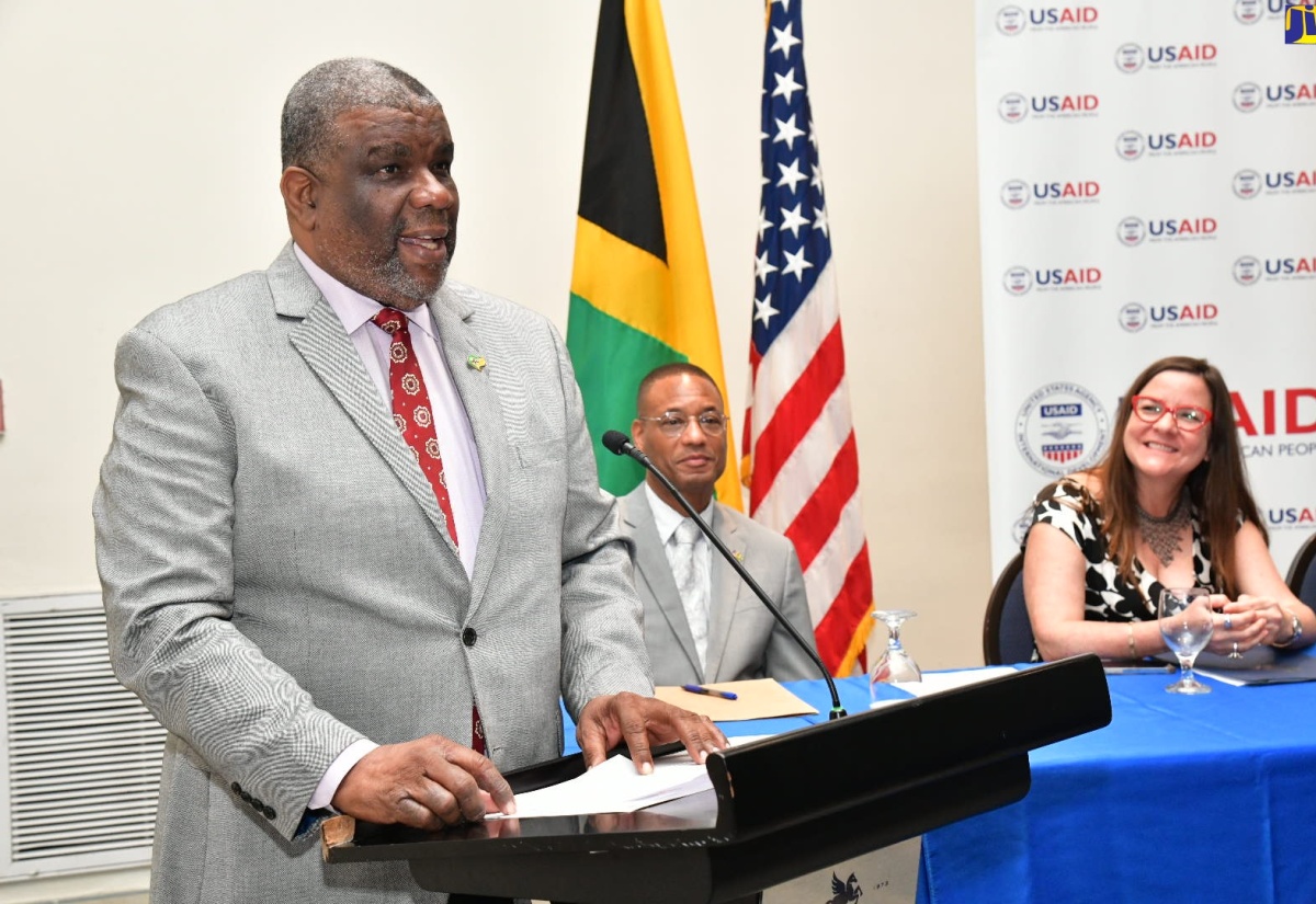 Permanent Secretary in the Ministry of Health and Wellness, Errol Greene, delivers an address on behalf of portfolio Minister, Dr. the Hon. Christopher Tufton, at the media launch of the One Health Project on Friday (Sept. 13) at the Jamaica Pegasus Hotel in New Kingston. Listening are Counsellor at the United States Agency for International Development (USAID), Clinton White, and Deputy Chief of Mission at the United States Embassy in Jamaica, Amy Tachco.