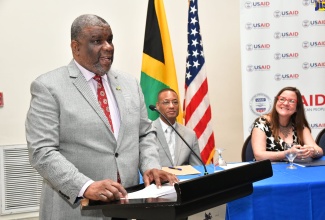 Permanent Secretary in the Ministry of Health and Wellness, Errol Greene, delivers an address on behalf of portfolio Minister, Dr. the Hon. Christopher Tufton, at the media launch of the One Health Project on Friday (Sept. 13) at the Jamaica Pegasus Hotel in New Kingston. Listening are Counsellor at the United States Agency for International Development (USAID), Clinton White, and Deputy Chief of Mission at the United States Embassy in Jamaica, Amy Tachco.