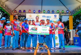 Executive Director, Social Development Commission (SDC), Dr. Dwayne Vernon (fourth left), presents a cheque valued $1.5 million to winner of the Social Development Commission (SDC) National Community T/20 Cricket Competition, Fairfield United, following their victory in the final held recently at Chedwin Park in St. Catherine.

