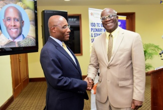 Industry, Investment and Commerce Minister, Senator the Hon Aubyn Hill (left), shakes hands with Executive Director of Bureau of Standards Jamaica (BSJ), Dr. Velton Gooden, at the BSJ Starch Stakeholders’ Symposium on September 19 at the University of the West Indies (UWI) Regional Headquarters, St. Andrew.

