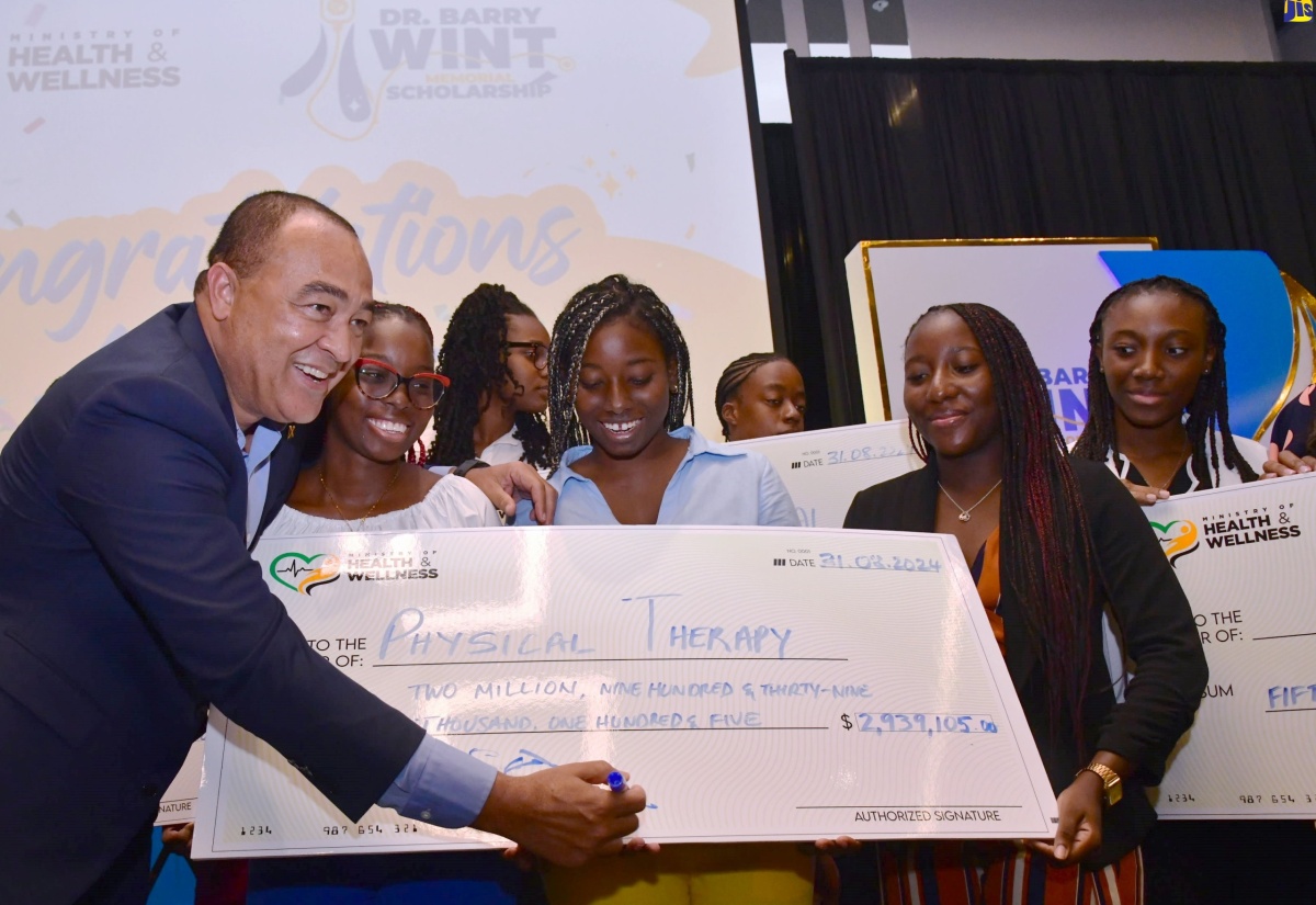 Minister of Health and Wellness, Dr. the Hon. Christopher Tufton (left), with some of the over 500 scholarship awardees at the recent ceremony, held at the AC Mariott Hotel, in New Kingston.

