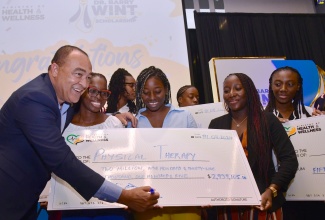 Minister of Health and Wellness, Dr. the Hon. Christopher Tufton (left), with some of the over 500 scholarship awardees at the recent ceremony, held at the AC Mariott Hotel, in New Kingston.

