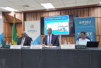 Director General, Planning Institute of Jamaica (PIOJ), Dr. Wayne Henry (centre), speaks during the agency’s June 2024 quarterly media briefing on Wednesday (September 4). Listening (from left) are PIOJ Senior Director, Economic Planning and Research, James Stewart; and Vision 2030 Jamaica Programme Director, Peisha Bryan Lee.

