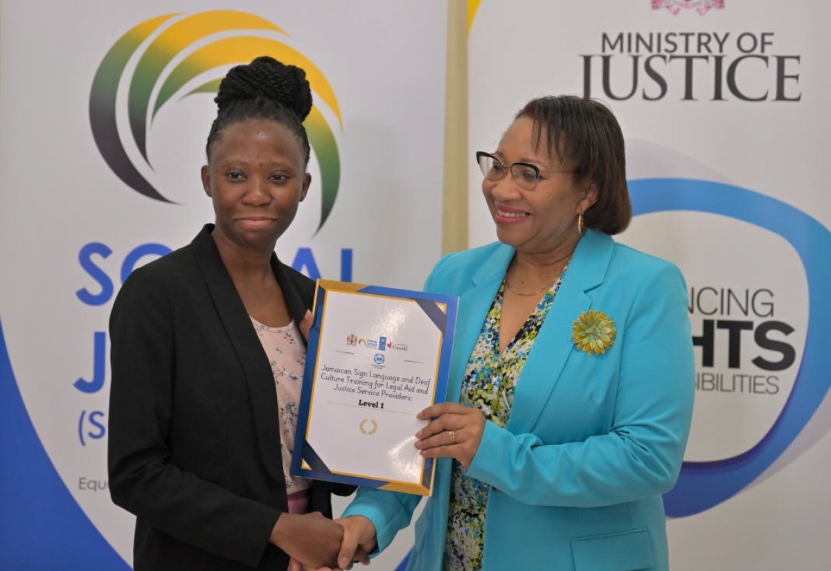 Ministry of Justice Officer, Shanielle Thompson (left), receives her certificate from Permanent Secretary, Grace Ann Stewart McFarlane, after completing a six-week Jamaican  Sign Language and Deaf Culture Training Course. The presentation was made during a graduation ceremony at Golf View Hotel in Mandeville, Manchester, on Thursday (September 12).
