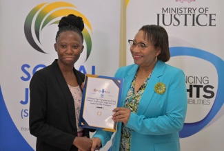 Ministry of Justice Officer, Shanielle Thompson (left), receives her certificate from Permanent Secretary, Grace Ann Stewart McFarlane, after completing a six-week Jamaican  Sign Language and Deaf Culture Training Course. The presentation was made during a graduation ceremony at Golf View Hotel in Mandeville, Manchester, on Thursday (September 12).
