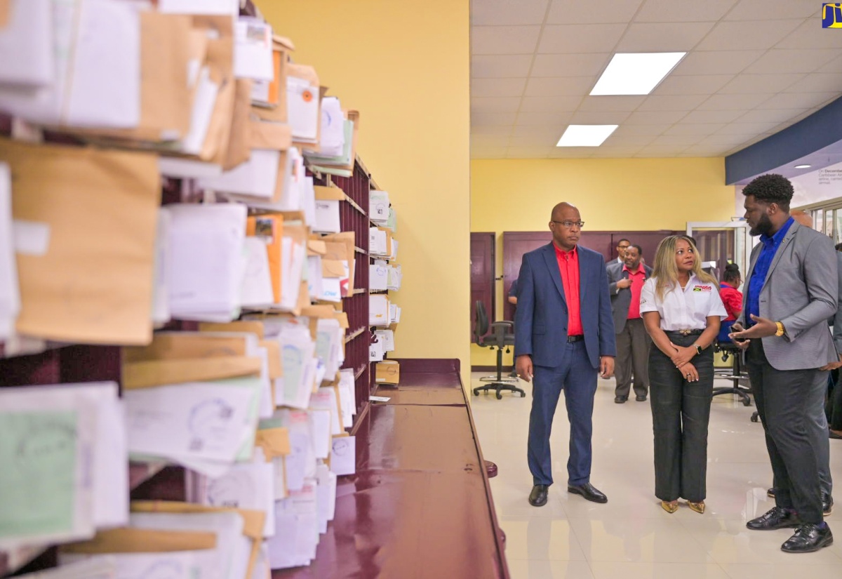 Minister without Portfolio in the Office of the Prime Minister, Senator Dr. the Hon. Dana Morris Dixon (centre) and Postmaster General/Chief Executive Officer, Jamaica Post, Lincoln Allen (left), listen to Branch Manager, Liguanea Post Office, O’Jae Adlam, during a tour of the newly renovated Liguanea Post Office at the reopening ceremony, held at the Liguanea Post Mall in St. Andrew, on September 17.

