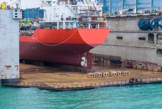 A ship undergoing maintenance work at a floating dry dock, similar to the one being operated in Jamaica.