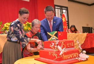 Minister of Foreign Affairs and Foreign Trade, Senator the Hon. Kamina Johnson Smith (left), joins Chinese Ambassador to Jamaica, His Excellency Chen Daojiang (right) and President of the Jamaica China Friendship Association, Irena Cousins, in a cutting a cake to celebrate the 75th anniversary of the founding of the People’s Republic of China, during the Association’s annual banquet held at The Jamaica Pegasus hotel in New Kingston on Sunday (October 13).

